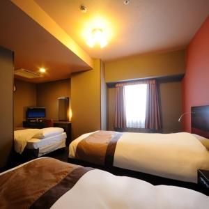 a hotel room with two beds and a window at Hotel Monte Hermana Sendai in Sendai