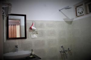 y baño con lavabo y espejo. en Junglaat Ecorganic Stays & Experiences en Dharamshala