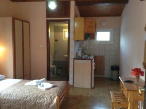 a small room with a bed and a kitchen at Studios LaLu in Skiathos