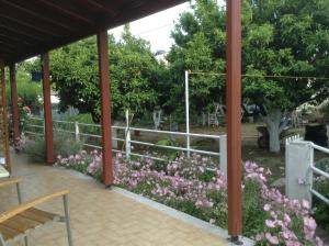 a garden with pink flowers and a white fence at Studios LaLu in Skiathos