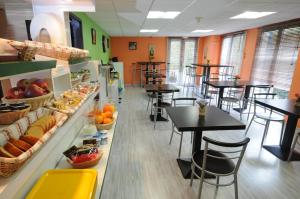 - un restaurant avec des tables, des chaises et des fruits dans l'établissement Mister Bed Lomme, à Lomme