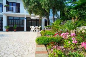 a courtyard of a building with flowers and plants at Rooms Amfora in Krk