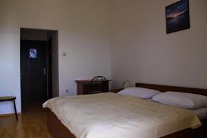 1 dormitorio con 2 camas, mesa y puerta en Rooms Amfora, en Krk