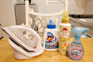 a table with a phone and bottles of cleaner at K-HOUSE Naha Maejima in Naha +29 photos
