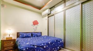 a bedroom with a blue comforter on a bed at New Fox Guest House in Zhuangwei