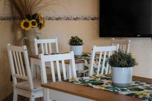 a table with four chairs and a table with potted plants on it at Dimora Di Campagna in Portella di Mare