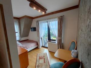 グリツァルフにあるPokoje Janka Gliczarów Górnyのベッドと窓が備わる小さな客室です。