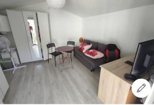 een woonkamer met een bank en een tafel bij Chalet Aurore in Mérignac