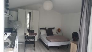 een kleine slaapkamer met een bed en een tafel bij Chalet Aurore in Mérignac