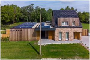 una casa con paneles solares en el techo en Bleekhoeve, en Olen