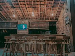Zimmer mit einer Bar mit Stühlen und einem TV in der Unterkunft Bata Merah Homestay in Banyuwangi