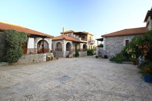 a stone courtyard with a house in the background at Stephanou Inn in Agios Nikolaos