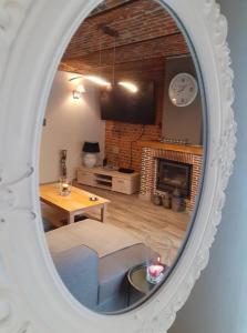 a mirror reflecting a living room with a fireplace at Le Charm'en Gîte in Tournai