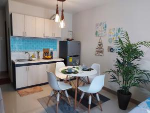 a kitchen with a table and chairs in a kitchen at Hachiko Pretty Homes Condominium at Saekyung956 Condominium, Looc, Lapu-lapu City, Cebu, Philippines in Mactan