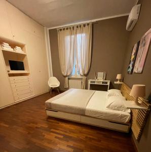 - une chambre avec un grand lit et une fenêtre dans l'établissement Villa Donatella, à Parme