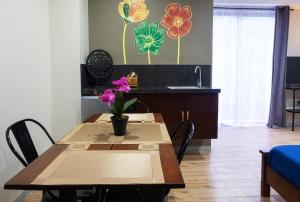 eine Küche mit einem Tisch mit Blumen an der Wand in der Unterkunft Luis miguel's place in Dumaguete