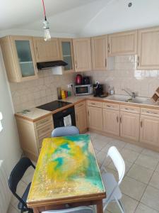 a kitchen with a table with a painting on it at Au coeur de Chantilly in Chantilly