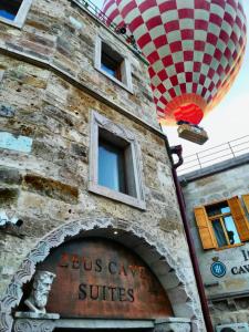 a brick building with a hot air balloon above it at Zeus Cave Suites in Göreme