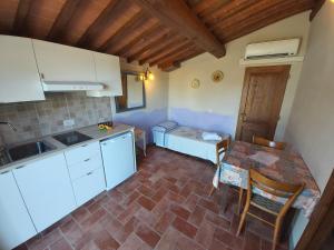 kuchnia ze stołem i łóżko w pokoju w obiekcie Colonica Poggio Renai w mieście Castelfranco di Sopra