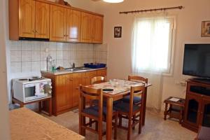 uma cozinha com uma mesa com cadeiras e um micro-ondas em Guesthouse "Athina" em Ellinikón