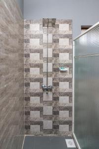 a bathroom with a shower with a glass door at Amaan Beach Bungalows in Nungwi