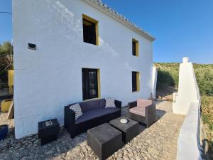 a white house with a couch and a table at Cortijo Las Rodrigas in Sabariego