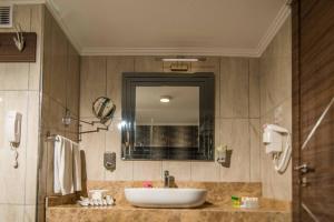 a bathroom with a sink and a mirror at Sandikli Thermal Park Hotel in Sandıklı