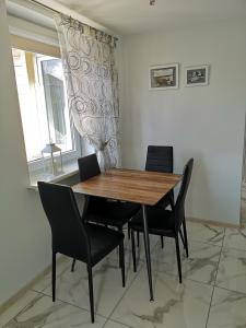 comedor con mesa de madera y sillas en Plungės gatvės 18 apartamentai en Telšiai