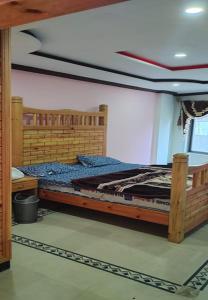 a bedroom with a wooden bed in a room at Zujaja Guest House in Bhurban