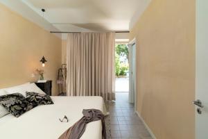 a bedroom with a white bed and a window at Suasor in Acireale