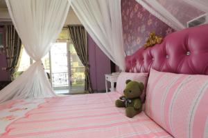 ein Teddybär auf einem rosa Bett in der Unterkunft Mei Lun Xi Pan Homestay in Hualien