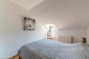 a white bedroom with a bed and a window at Chambre d'hôtes de la Fontagrille in Épineuil-le-Fleuriel