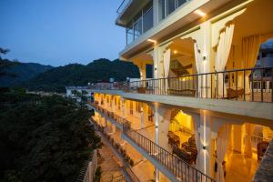a view of a building with a balcony at night at Maharishi Ayurveda-Boutique Wellness Retreat in Rishīkesh