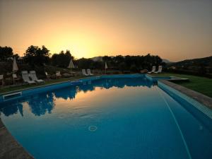 uma grande piscina azul com um pôr-do-sol ao fundo em B&B Il Rifugio di Nino em Contursi Terme
