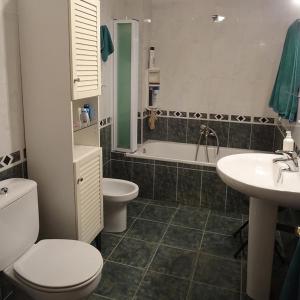 a bathroom with a toilet and a sink and a tub at INTRAMUROS alojamiento dentro de la muralla in Ávila