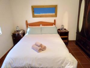 a bedroom with a bed with two towels on it at Franskraal-Bit of Salt-Rustic Family Beach House-From R1650 per night, sleeps 6,min 2 nights in Franskraal