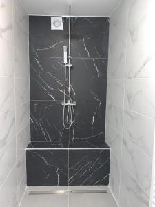 a bathroom with a black and white marble wall at Studio de Spa in Spa