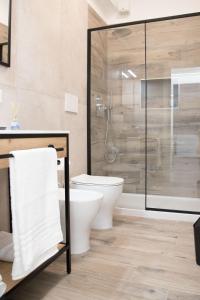 a bathroom with a toilet and a glass shower at Appartamento il Mulino in Orbetello