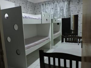 Cette chambre comprend 2 lits superposés et une chaise. dans l'établissement Floresta - Enseada Guarujá, à Guarujá 106 autres photos