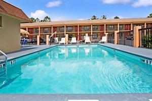 a large swimming pool in front of a hotel at Super 8 by Wyndham Kissimmee/Maingate/Orlando Area in Orlando