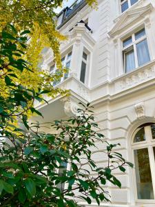 a white house with a tree in front of it at Apartment in Pempelfort - Central in Düsseldorf