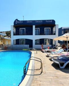 a hotel with a swimming pool in front of a building at Eleni Beach Apartment in Stalida