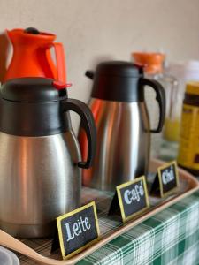 zwei Kessel auf einem Teller auf einem Tisch in der Unterkunft Pousada Natureza e Arte in Cunha