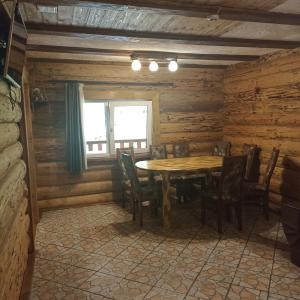a dining room with a wooden table and chairs at Khatyna u Dolyni in Slavske