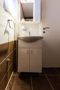 La salle de bains est pourvue d'un lavabo et d'un miroir. dans l'établissement Hostel Sunset, à Zadar