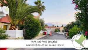 a house with a palm tree on a street at Hotel & Spa Gil de France Cap d'Agde in Cap d'Agde