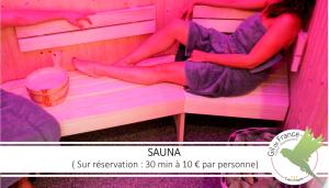 a woman sitting on a bunk bed in a pink room at Hotel & Spa Gil de France Cap d'Agde in Cap d'Agde