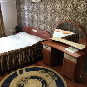 a bedroom with a bed and a desk and a rug at Ідилія in Zhensna Polʼska
