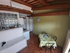 uma pequena cozinha com uma mesa e um balcão em Colonica Poggio Renai em Castelfranco di Sopra