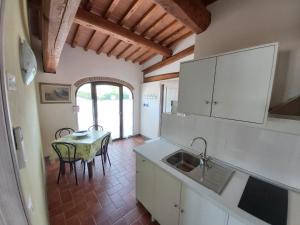 uma cozinha com uma mesa e um lavatório em Colonica Poggio Renai em Castelfranco di Sopra